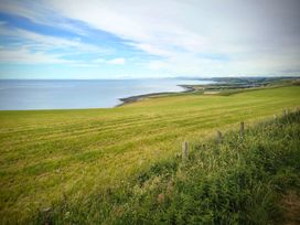 A view of the sea and grassland at Fir Tree Shepherd's Hut in Llanon