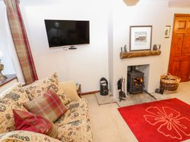 A living room with a television and a fireplace at Coldbeck Cottage in Ravenstonedale