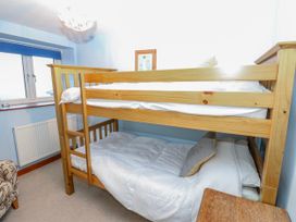 A bunk bed with white bedding in a bedroom at Coldbeck Cottage in Ravenstonedale