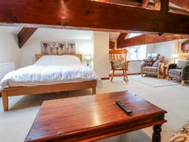 A bedroom with a bed and seating area at Coldbeck Cottage in Ravenstonedale