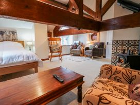 A bedroom with a bed, chairs, and a coffee table at Coldbeck Cottage Ravenstonedale