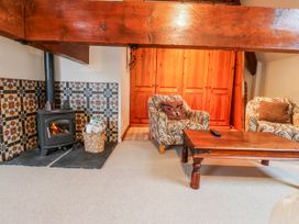 A living room with a fireplace and two armchairs at Coldbeck Cottage in Ravenstonedale