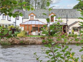 A house with a conservatory by a river at Beckside Cottage Penrith