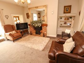 A living room with a sofa and an armchair at Beckside Cottage in Penrith