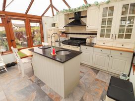 A kitchen with an island and cabinets at Beckside Cottage in Penrith