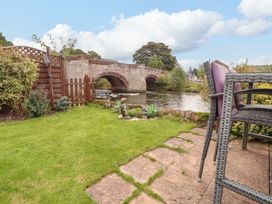 A garden with a view of a bridge over a river at Beckside Cottage in Penrith
