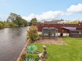 A garden area with a river and furniture at Beckside Cottage in Penrith