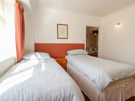 A bedroom with two single beds and a bedside table at Garden Cottage in Surlingham near Poringland
