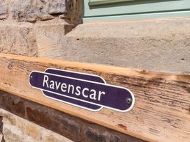 A wooden bench with a Ravenscar nameplate attached at Wayside Farm Dairy Cottage in Cloughton near Burniston