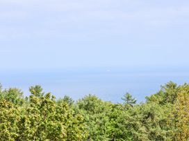 A view of the ocean with trees in the foreground at Wayside Farm Dairy Cottage in Cloughton near Burniston