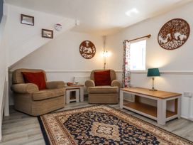 A sitting room with two armchairs a patterned rug a coffee table and wall decorations at Wayside Farm Dairy Cottage Cloughton near Burniston