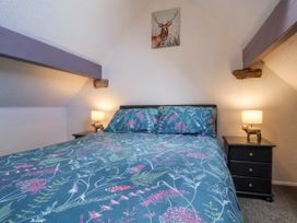 A bedroom with a bed and two bedside tables with lamps at Wayside Farm Dairy Cottage Cloughton near Burniston