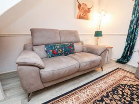 A living room with a sofa and lamp at Wayside Farm Dairy Cottage Cloughton near Burniston