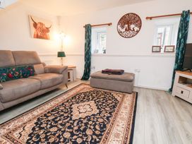 A living room with a sofa and ottoman at Wayside Farm Dairy Cottage Cloughton near Burniston