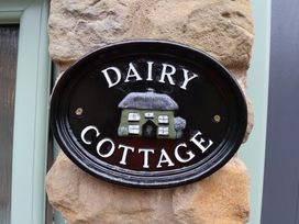 A Dairy Cottage sign on a stone wall at Wayside Farm Dairy Cottage Cloughton near Burniston