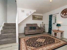 A living room with a sofa and a rug at Wayside Farm Dairy Cottage in Cloughton near Burniston