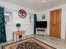 A living room with a television stand and curtains at Wayside Farm Dairy Cottage Cloughton near Burniston