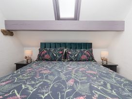 A bedroom with a bed and bedside lamps at Wayside Farm Dairy Cottage in Cloughton near Burniston