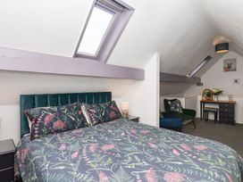 A bedroom with a bed and armchair at Wayside Farm Dairy Cottage Cloughton near Burniston