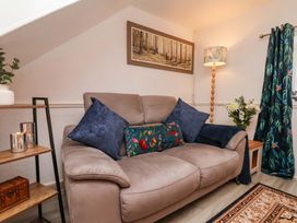 A living room with a sofa and lamp at Wayside Farm Dairy Cottage in Cloughton near Burniston