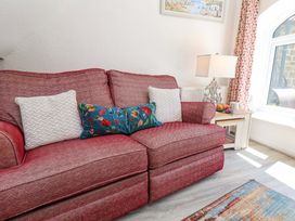A living room with a sofa and decorative pillows at Wayside Farm Stable Cottage Cloughton near Burniston