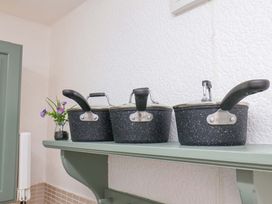 A shelf with three pans and a flower at Wayside Farm Stable Cottage in Cloughton near Burniston