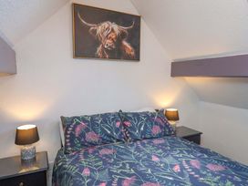 A bedroom with a bed and lamps at Wayside Farm Stable Cottage in Cloughton near Burniston