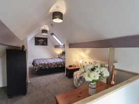 A bedroom with a bed and bedside table at Wayside Farm Stable Cottage in Cloughton near Burniston