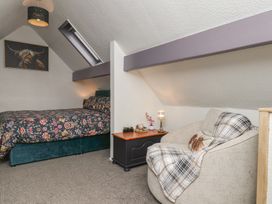 A bedroom with a bed and a chair at Wayside Farm Stable Cottage Cloughton near Burniston