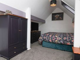 A bedroom with a bed, wardrobe, and dresser at Wayside Farm Stable Cottage Cloughton near Burniston