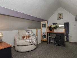 A bedroom with an armchair and dressing table at Wayside Farm Stable Cottage Cloughton near Burniston