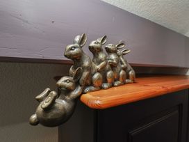 A decorative item featuring bronze bunnies on a wooden shelf at Wayside Farm Stable Cottage Cloughton near Burniston