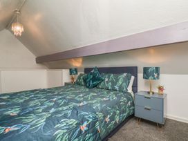 A bedroom with a bed and bedside table at Wayside Farm Cart Cottage in Cloughton near Burniston