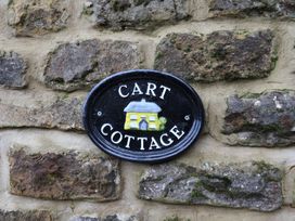 A sign reading 'CART COTTAGE' on a stone wall at Wayside Farm Cart Cottage Cloughton near Burniston