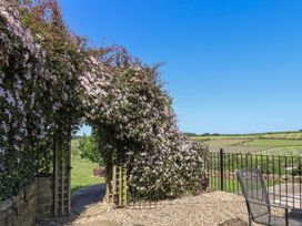 An outdoor area with flowers and a gate at Wayside Farm Cart Cottage in Cloughton near Burniston