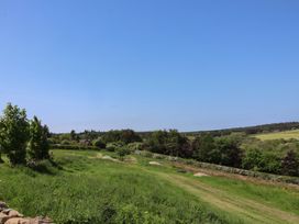 A landscape view with trees and open fields at Wayside Farm Cart Cottage Cloughton near Burniston