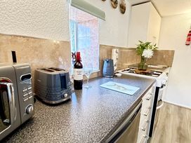 A kitchen with a toaster and kettle on the work surface at Wayside Farm Cart Cottage in Cloughton near Burniston