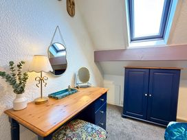 A bedroom with a desk and a lamp at Wayside Farm Cart Cottage Cloughton near Burniston