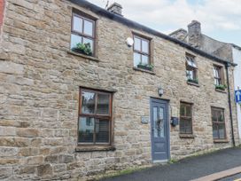 A stone building with windows and a front door at Mill Race House in Alston
