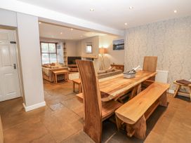 A dining room with a wooden table and benches at Mill Race House in Alston