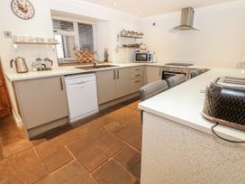 A kitchen with appliances and storage at Mill Race House Alston