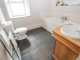 A bathroom with a bath tub, toilet, and sink at Mill Race House in Alston