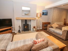 A living room with a television and sofa at Mill Race House in Alston