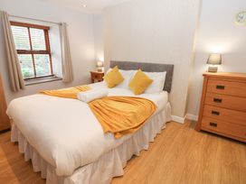 A bedroom with a bed and bedside table at Mill Race House in Alston