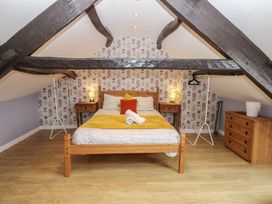 An attic bedroom with a bed and dresser at Mill Race House in Alston