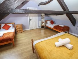 A bedroom with three beds and a dresser at Mill Race House in Alston