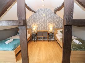A bedroom with two beds and a wooden beam at Mill Race House in Alston