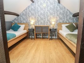 A bedroom with two beds and a storage unit at Mill Race House Alston