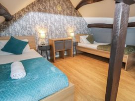 A bedroom with two beds and a cabinet at Mill Race House in Alston