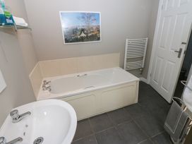 A bathroom with a bathtub and sink at Mill Race House Alston